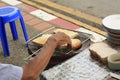 Man toasting bread on an open coal fire