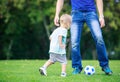 Man and toddler son playing football in park Royalty Free Stock Photo