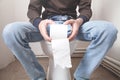 Man in toilet and holding paper roll Royalty Free Stock Photo