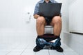 Man in toilet using laptop Royalty Free Stock Photo