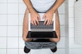 Man in toilet using laptop Royalty Free Stock Photo