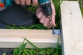 Man, tool, drilling into the construction of the boards on the grass Royalty Free Stock Photo