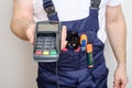 Man with tools holding bank payment terminal