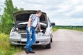 Man with tools waiting to help near broken car