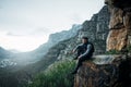 The man on top of the mountain didnt fall there. a young man looking at the view while sitting on a mountain cliff. Royalty Free Stock Photo