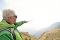 Man on top of the mountain pointing at something