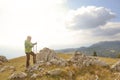 Man on top of the mountain pointing at something