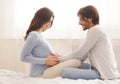 Man touching belly of his pregnant wife in bed at home Royalty Free Stock Photo