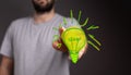 Man touching 3D rendered green light bulb icon with his two fingers