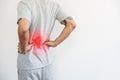 A man touching his back, with red highlight. Back pain, backache and waist pain, on white background with copy space