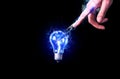 Man touching the lamp bulb. New idea concept. Blue lightning. Isolated on black background Royalty Free Stock Photo