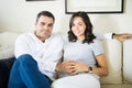 Man Touching Woman`s Belly To Feel Baby Bump At Home