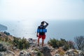 Man Tourism traveler hiker with a backpack and cowboy hat standing on the top rock and enjoi nature. Sea and mountains. travel Royalty Free Stock Photo