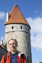 The man, tourist on a background of an ancient tower of a city wall. Tallinn, Estonia. Royalty Free Stock Photo