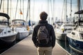 a man tourist with a backpack on a pier with yachts. Generative AI