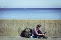 Man tourist backpacker sitting with tablet outdoor Royalty Free Stock Photo