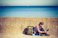 Man tourist backpacker sitting with tablet outdoor Royalty Free Stock Photo