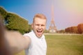 Man tourist Eiffel tower making selfie and smiling. Beautiful European guy enjoying vacation in Paris, France. Concept Royalty Free Stock Photo