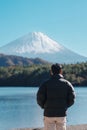 man tourist enjoy with Fuji Mountain at Lake Saiko, happy Traveler sightseeing Mount Fuji and road trip Fuji Five Lakes. Landmark Royalty Free Stock Photo