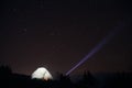 Tourist with flashlight near his camp tent under a sky full of stars, night mountain loneliness Royalty Free Stock Photo