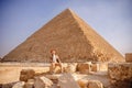 Man tourist with hat and bag walks background of pyramids in Giza Cairo Egypt, sun light travel Royalty Free Stock Photo