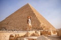 Man tourist with hat and bag walks background of pyramids in Giza Cairo Egypt, sun light travel Royalty Free Stock Photo
