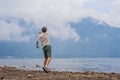 Man tourist at the lake Bratan and the mountains covered with cl