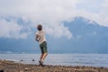 Man tourist at the lake Bratan and the mountains covered with clouds