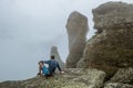 A man tourist on a rock admires the Demerdzhi mountain range on the Crimean peninsula