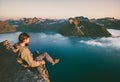 Man tourist sitting alone on the edge cliff mountains above sea