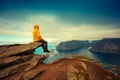 Man tourist sitting on a cliff of rock Royalty Free Stock Photo