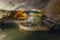 Man tourist speleologist in wetsuit with flashlight in beautiful natural cave Royalty Free Stock Photo