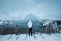 Man tourist standing on viewpoint of Reine town in blizzard on winter at Lofoten Islands Royalty Free Stock Photo