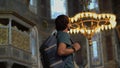 A man tourist stands in awe within the hallowed beauty of Istanbul's Ayasofya, immersed in the temple's majestic