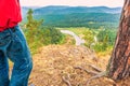 A mature male tourist stands on top of a mountain and admires the picturesque morning Ural view. Royalty Free Stock Photo