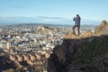 A man, tourist taking photo of city Edinburgh from top of mountain Royalty Free Stock Photo