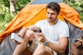 Man tourist using cell phone and portable mini speaker