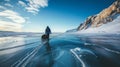 Man tourist walking on the ice of Baikal lake. Winter landscape of lake. Blue transparent cracked ice and the blue sky. Royalty Free Stock Photo