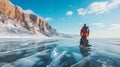 Man tourist walking on the ice of Baikal lake. Winter landscape of lake. Blue transparent cracked ice and the blue sky. Royalty Free Stock Photo