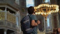 A man tourist, wearing a face mask, stands in awe within the hallowed beauty of Istanbul's Ayasofya, immersed in