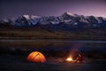 Man tourists sitting in the illuminated tent near campfire Royalty Free Stock Photo