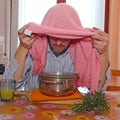 Man with towel breathe balsam vapors to treat colds Royalty Free Stock Photo