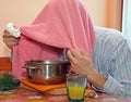 Man with towel breathe balsam vapors to treat colds and the flu Royalty Free Stock Photo
