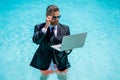 man trader work and relax. man trader work and relax in swimming pool. man trader work and relax