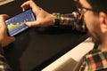 Man trading bitcoin on his phone with graph background. Businessman using the phone with financial graph on blurred dark