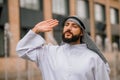 A man in traditional arabian clothing waving his hand Royalty Free Stock Photo