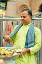 Man in traditional clothes selling Prasada outside of Shrinathji Temple, Nathdwara, India,vertical