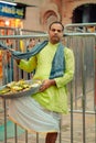 Man in traditional clothes selling Prasada outside of Shrinathji Temple, Nathdwara, India,vertical