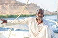 Man in traditional dress sailing a felucca boat on the Nile River