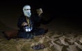 Man in traditional Tuareg outfit making tea in a desert Royalty Free Stock Photo